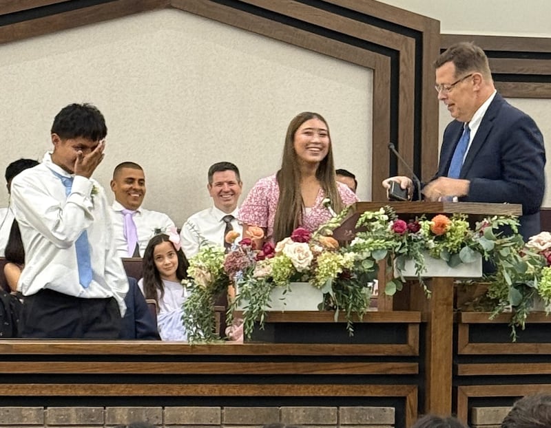 Jose Coy, 18, e Loreana Arguedas, 16, estão com Élder Clark G. Gilbert do Quórum dos Doze Apóstolos no Centro de Estaca Schaumburg Illinois em Chicago, Illinois no domingo, 20 de setembro de 2026.