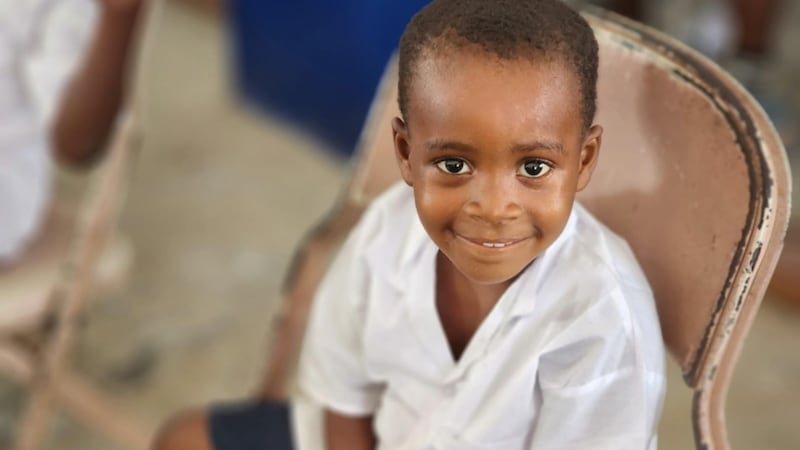 Uma criança sorri durante a cerimônia marcando a doação de novas salas de aula e suprimentos em uma escola primária em Lower Margibi County, Libéria, 21 de fevereiro de 2026.