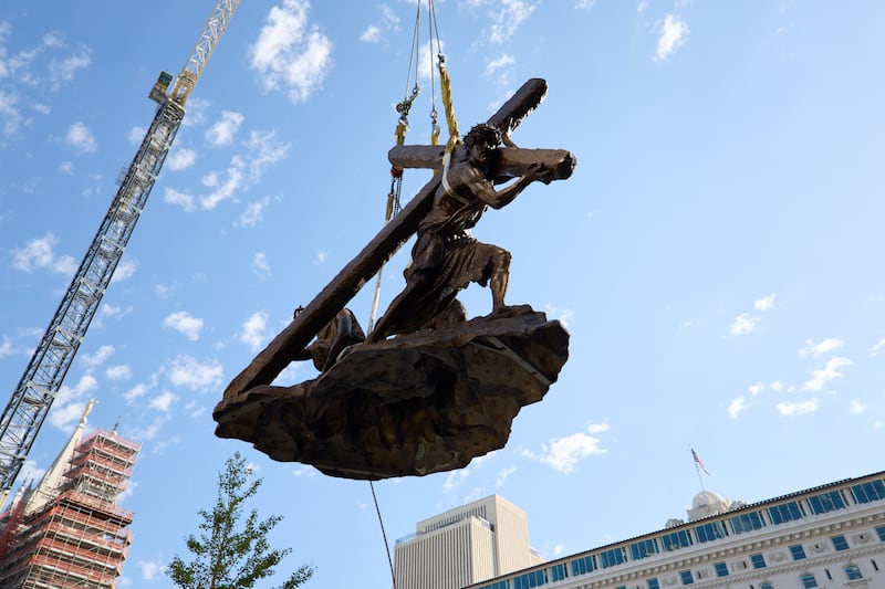 Membros da equipe instalam a estátua \“Jesus Cristo Carregando a Cruz\”, criada por Michael Hall, logo ao sul do Templo de Salt Lake na quarta-feira, 17 de setembro de 2025.