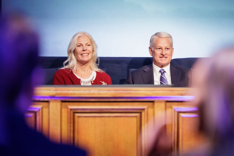 Elder John A. McCune, um Setenta Autoridade Geral, e sua esposa, Sister Debbra McCune, sentam-se na tribuna no Marriott Center em Provo, Utah, antes do devocional da BYU na terça-feira, 9 de dezembro de 2025.