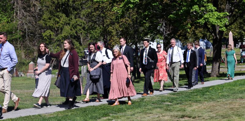 Moradores de Topsfield e membros da família Smith se dirigem a uma grande tenda perto do Memorial da Família Smith, antes da cerimônia de dedicação no Cemitério Pine Grove em Topsfield, Massachusetts, em 14 de maio de 2022.