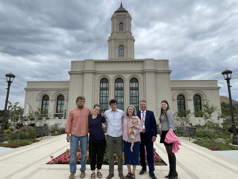 Christian Davidson, segundo da direita, e sua esposa, Esther Davidson, terceira da direita, estão em pé com membros da família fora do Templo de Cody Wyoming em 2026. Os Davidsons serviram como coordenadores do comitê de casa aberta e dedicação do templo de Cody.
