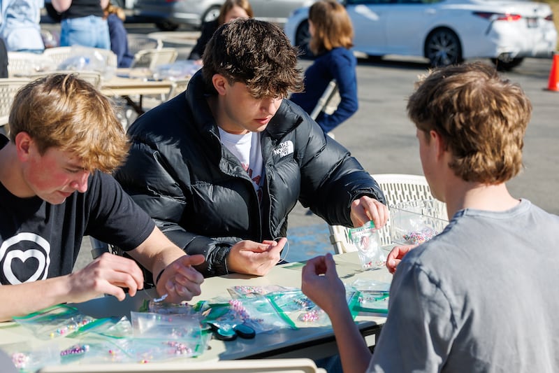 Três estudantes do ensino médio montam pulseiras durante um projeto de serviço em Meridian, Idaho, sexta-feira, 27 de fevereiro de 2026.