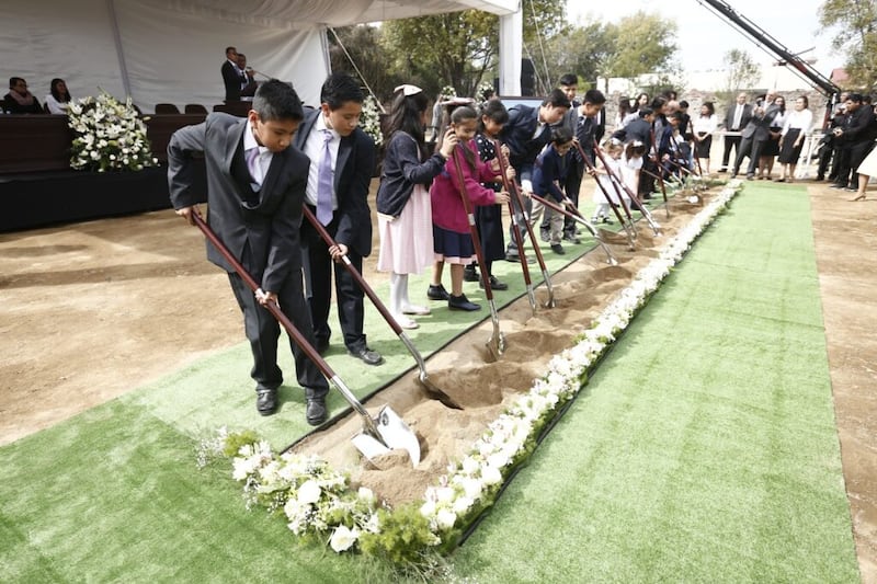 Crianças Santos dos Últimos Dias levantam pá cheia de terra na abertura de terra do Templo de Puebla México, no sábado, dia 30 de novembro, 2019.