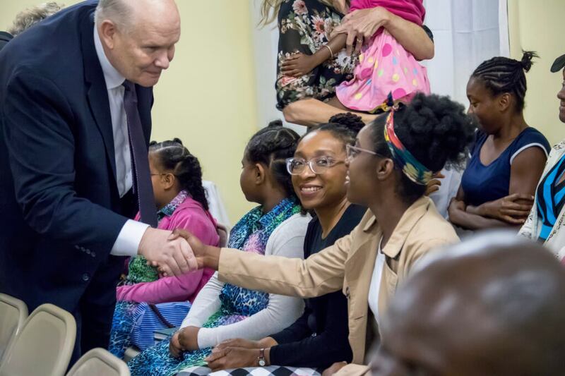 Élder Dale G. Renlund aperta a mão de uma menina em Dominica durante uma visita à Área Caribe no dia 16 de fevereiro, 2020.