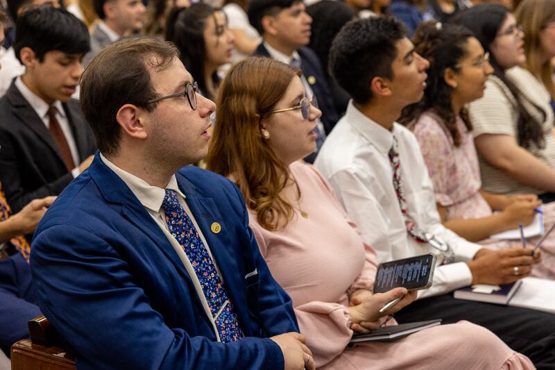 Jovens adultos ouvem o Élder Dale G. Renlund do Quórum dos Doze Apóstolos durante o devocional de Buenos Aires, Argentina, em 11 de novembro de 2025.
