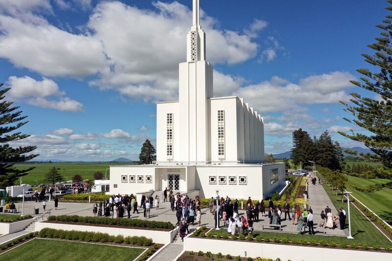 Pessoas se reúnem do lado de fora do Templo de Hamilton Nova Zelândia, entre as sessões da rededicação do templo no domingo, 16 de outubro de 2022.