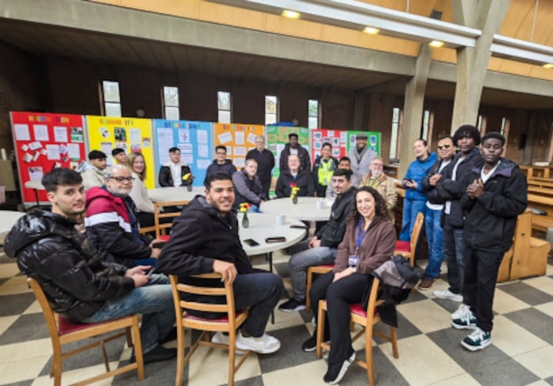 Estudantes e professores fazem uma pausa para uma foto durante uma aula semanal de EnglishConnect no prédio do Ramo Stevenage na Estaca da Inglaterra de St. Albans em Dorset, Inglaterra, no início de 2026.
