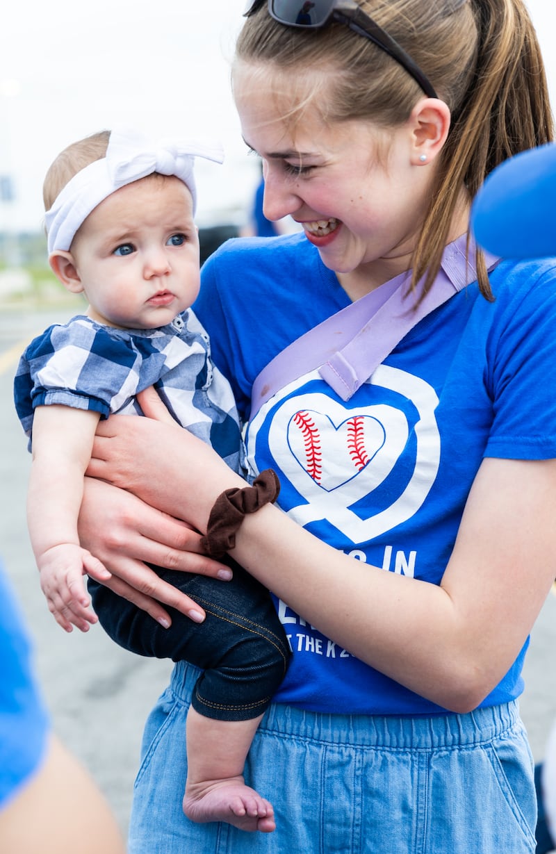 Uma voluntária para para uma foto com sua irmã mais nova em uma noite do JustServe no jogo do Kansas City Royals em Kansas City, Missouri, em 9 de abril de 2026.