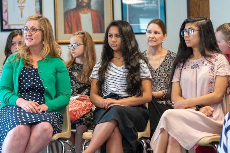 Jovens mulheres ouvem durante uma aula no domingo.