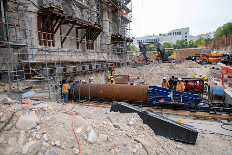 As equipes de trabalhadores inserem um tubo de aço debaixo da fundação existente do Templo de Salt Lake, como parte de um processo de reforço sísmico denominado “jack and bore” (escavação e perfuração), setembro de 2021.