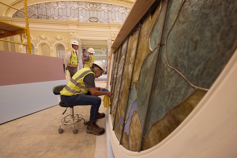 Durante a instalação, um trabalhador limpa uma peça de vidro artístico com Adão e Eva na terça-feira, 21 de abril de 2026, em Salt Lake City. A obra de arte estará na sala celestial do Templo de Salt Lake d'A Igreja de Jesus Cristo dos Santos dos Últimos Dias.