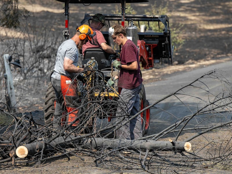 Homens jovens e líderes da Estaca Mount Spokane de Spokane Washington ajudam a remover escombros de um bairro danificado por incêndios florestais em Spokane, Washington, na segunda-feira, 3 de agosto de 2026.