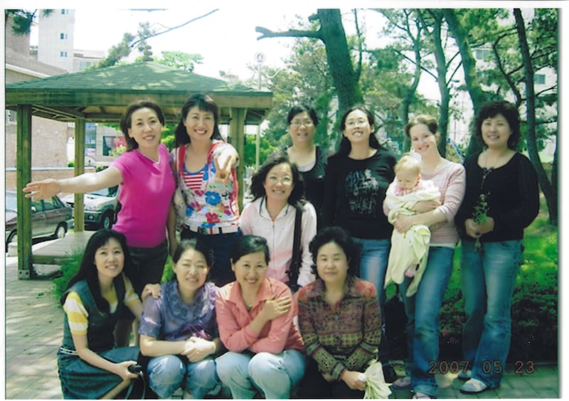 Traci Law — compositora do novo hino "Little Baby in a Manger," à direita — sorri com irmãs de seu ramo em Ulsan, Coreia, em 2007.