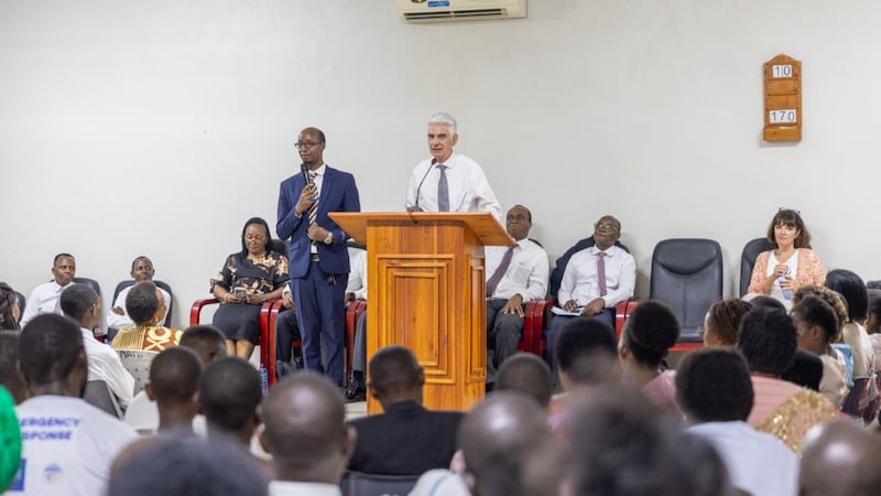 Élder Gérald Caussé fala em um púlpito aos membros durante sua visita a Bujumbura, Burundi, 21 de outubro de 2026.