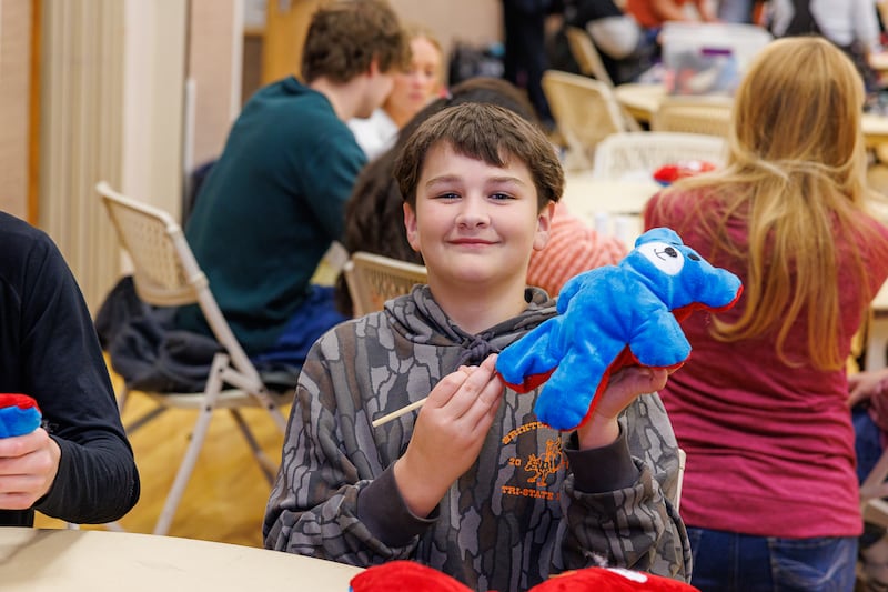 Um garoto do ensino médio segura um urso de pelúcia que ele montou durante um projeto de serviço de Meridian, Idaho, sexta-feira, 27 de fevereiro de 2026.