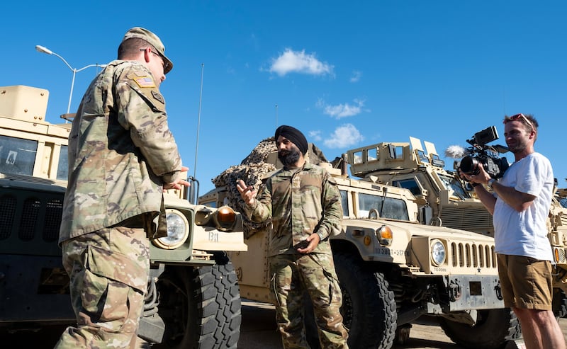 Tenente-coronel do Exército dos EUA Simratpal "Simmer" Singh conversa com um colega soldado durante a filmagem de um episódio de "Voices for Faith".