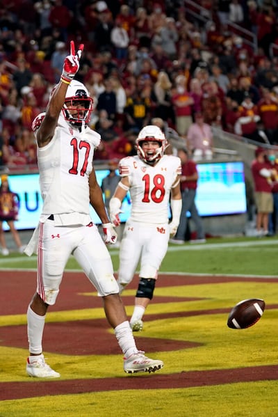O receptor da Universidade de Utah, Devaughn Vele (17), comemora seu touchdown com o companheiro de time, o missionário retornado Britain Covey (18) durante a primeira metade do jogo de do time de futebol americano universitário contra a Universidade do Sul da Califórnia no sábado, 9 de outubro de 2021, em Los Angeles.