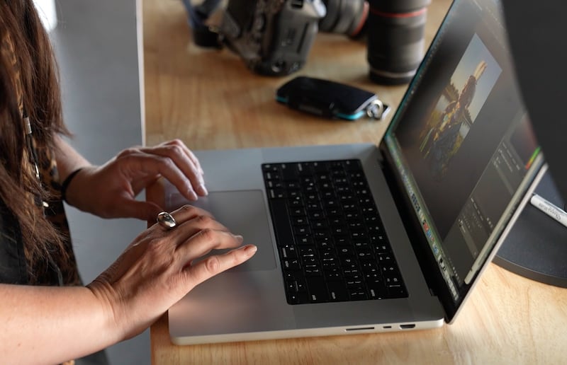 A fotógrafa de A Igreja de Jesus Cristo dos Santos dos Últimos Dias Tina Smith organiza e edita fotos em seu laptop.