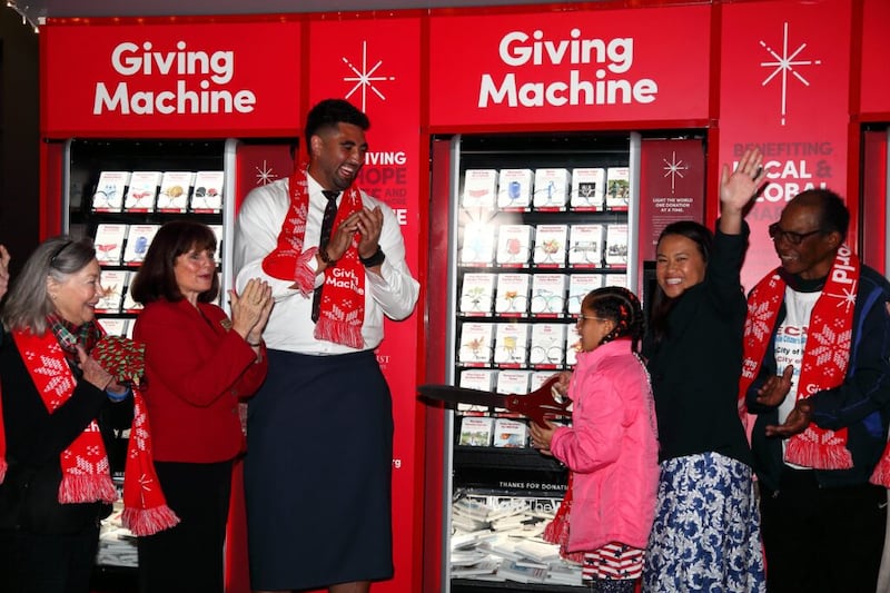 O jogador de futebol americano do San Fransisco 49ers, Corbin Kaufusi, aplaude enquanto a fita inaugural é cortada para as Máquinas de Doações em Oakland Temple Hill no sábado, 27 de novembro de 2021.