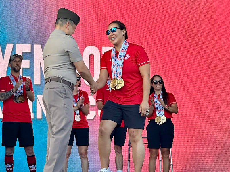 O aposentado major do Corpo de Fuzileiros Navais dos EUA Yen Soto recebe quatro medalhas de ouro após a competição de natação nos Jogos dos Guerreiros 2025, em Colorado Springs, Colorado.