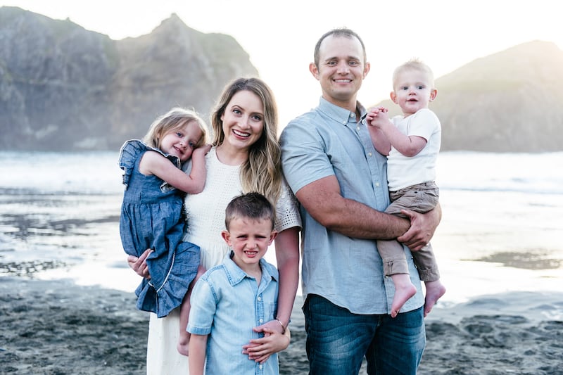 Angie Killian, compositora de "Anytime, anywhere", posa com sua família para uma foto na Gold Beach em Oregon em 2019, o ano em que "Anytime, anywhere" foi escrita.