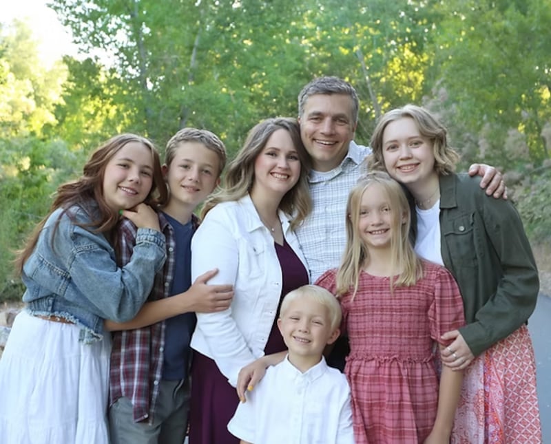 Traci Law — compositora do novo hino "Little Baby in a Manger," ao centro — sorri para um retrato com sua família em Spanish Fork, Utah, 2021.