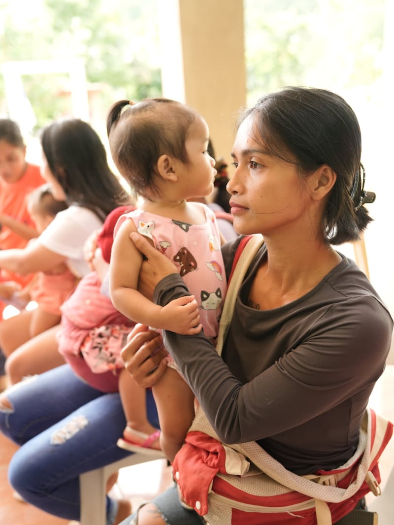 Uma mãe e uma criança participam de um exame nutricional nas Filipinas, agosto de 2025.