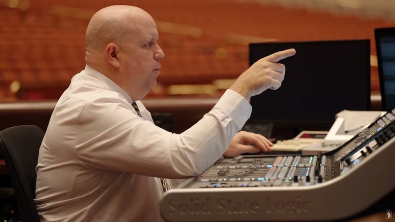 Aaron Kobel, um engenheiro de áudio da Igreja, testa o som do áudio do microfone antes da conferência geral.