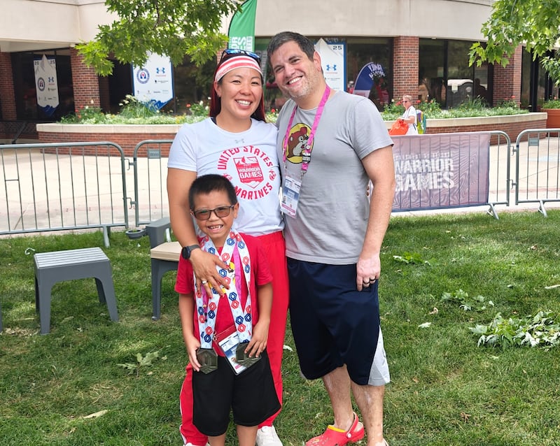 Aposentada Major da Marinha dos EUA Yen Soto posa para uma foto com seu marido, Andrew Soto, e filho, Kenji Soto, nos Jogos dos Guerreiros de 2025 em Colorado Springs, Colorado.