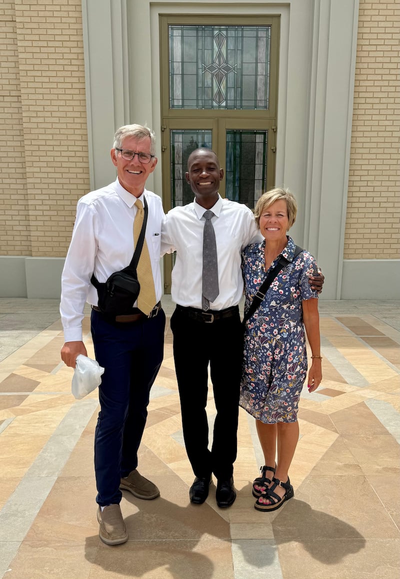 Kilford Shereni é fotografado com Bruce e Elizabeth Anderson do lado de fora do Templo de Harare, Zimbábue.