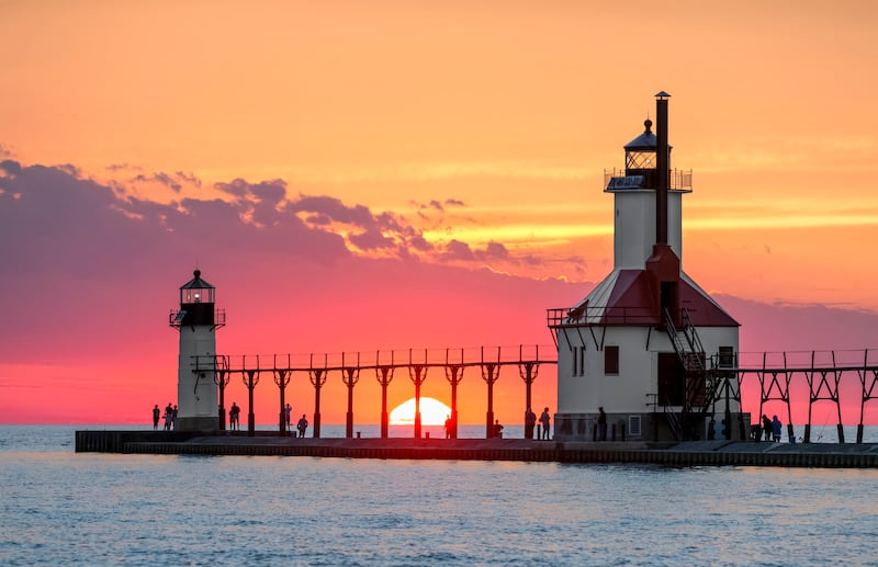 No solstício de verão, o sol se põe no Lago Michigan entre os Faróis da Doca Norte Interna e Externa em St. Joseph, Michigan.