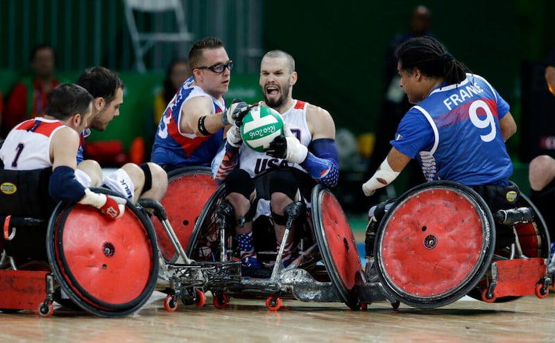Josh Wheeler, no centro, dos Estados Unidos, luta pela bola com o francês Riadh Sallem, à direita, e Christophe Salegui durante uma partida mista de rúgbi em cadeira de rodas do grupo B nos Jogos Paralímpicos do Rio de Janeiro, Brasil, quarta-feira, 14 de setembro de 2016.