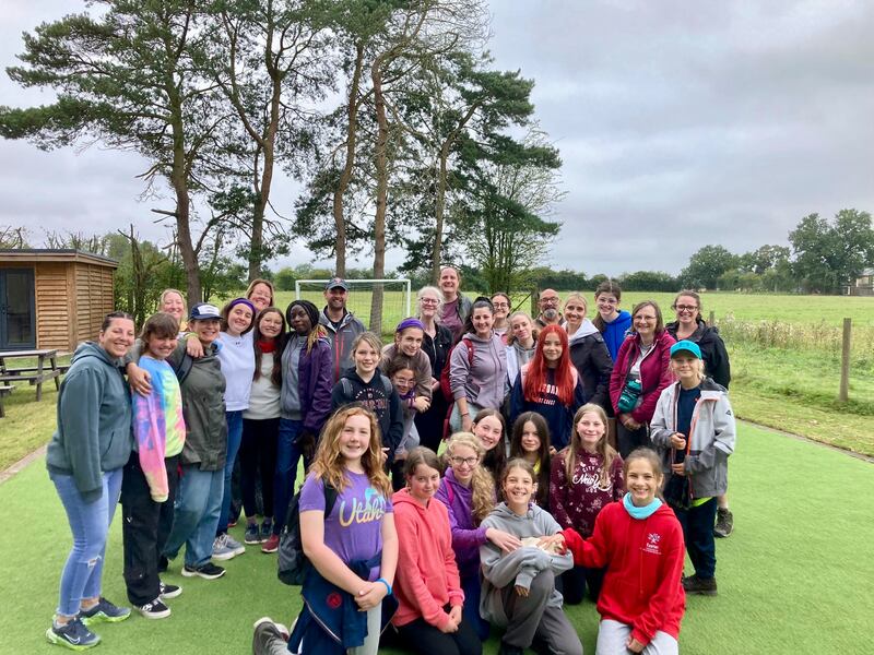 Um grupo de jovens mulheres de 11 a 13 anos e suas líderes da Estaca Northampton Inglaterra posam para uma foto durante uma atividade de serviço na Escola Northleigh House em agosto de 2024.