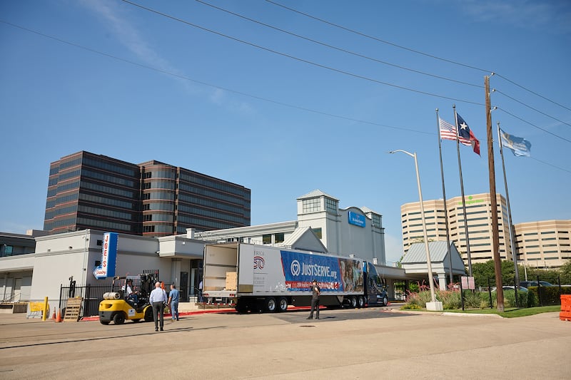 Voluntários ajudam a descarregar caixas de alimentos entregues de A Igreja de Jesus Cristo dos Santos dos Últimos Dias para Joe's Food Pantry em Dallas, Texas, na quinta-feira, 14 de maio de 2026.