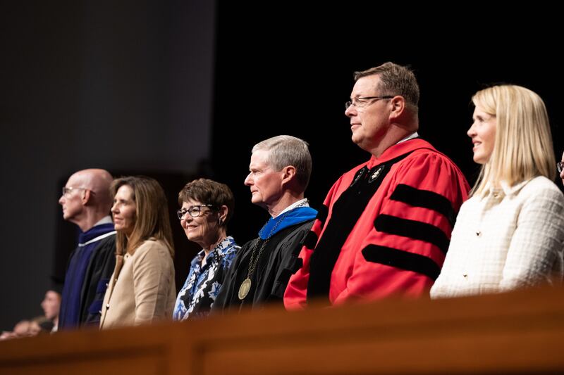 A partir da esquerda, Henry J. Eyring, presidente da BYU-Idaho, irmã Kelly Eyring, irmã Susan Bednar, Élder David A. Bednar, Élder Clark G. Gilbert e irmã Christine Gilbert, aguardam de pé enquanto os formandos entram no BYU-I Center para a formatura na quarta-feira, 19 de julho de 2023.