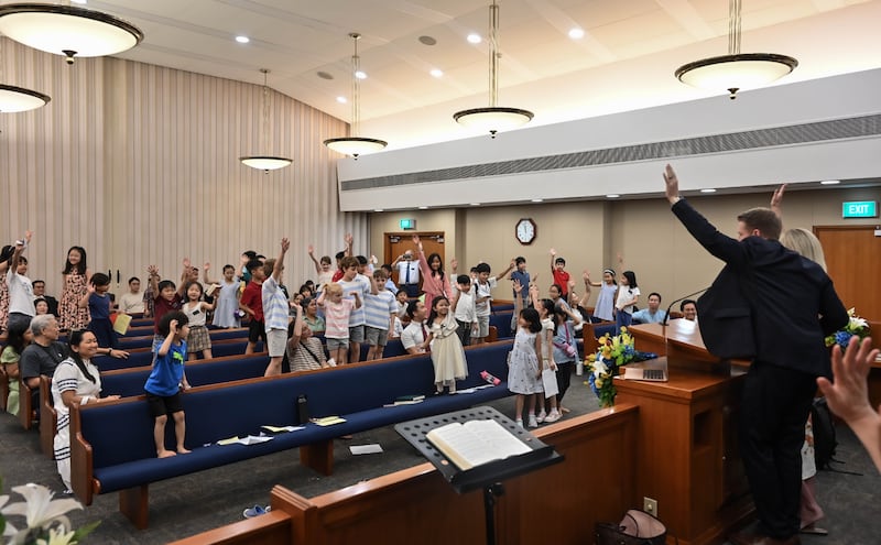 Durante seu ministério em Singapura, o Presidente Geral dos Rapazes Timothy L. Farnes convidou as crianças a se levantarem, erguerem as mãos e se comprometerem a ler as escrituras diariamente.