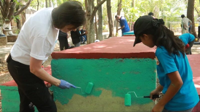 A Presidente Susan H. Porter ajuda uma menina a pintar partes de um parque público durante uma atividade de serviço em Tuxtla Gutiérrez, Chiapas, México, em maio de 2026.