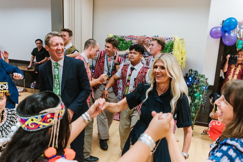 O Presidente Geral dos Rapazes Timothy L. Farnes, à esquerda, e sua esposa, irmã Linsey Farnes, interagem com jovens durante um festival de colheita Gawai em Sibu, Malásia, como parte de uma designação ministerial a países da Ásia, de 21 a 31 de maio de 2026.