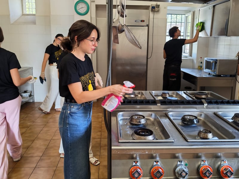 Jovens adultos solteiros da Sicília e de Malta limpam a cozinha da Casa Scalabrini 634 durante um projeto de serviço em Roma, Itália.