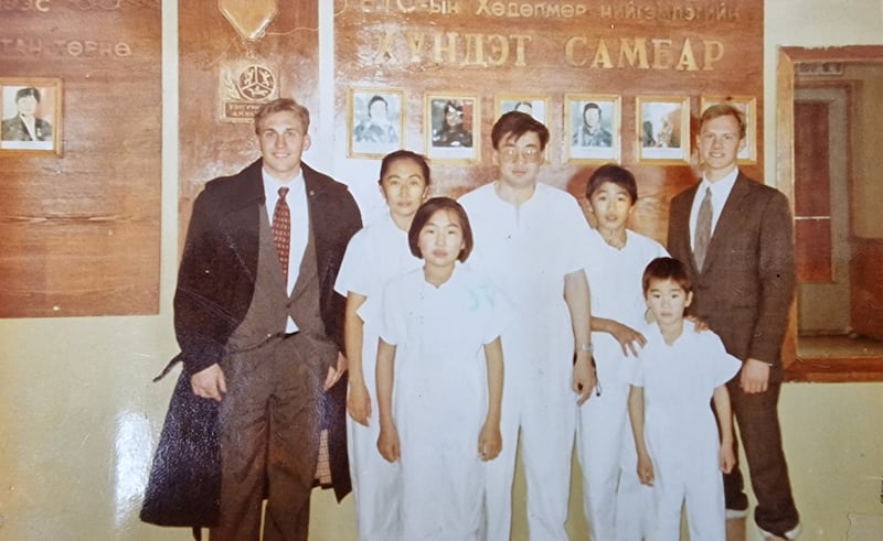 Elder Duane L. Blanchard e Elder Brett A. Hansen com a família de Togtokhin Enkhtuvshin e Doyodiin Dashgerel em 1993 na Mongólia, antes de Enkhtuvshin batizar sua esposa e filhos.