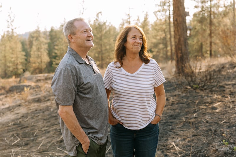 De pé nas cinzas não muito longe de sua casa, Todd e Debbie Rogers contam a história de como sua casa sobreviveu aos incêndios florestais de Spokane em Spokane, Washington, no sábado, 22 de agosto de 2026.