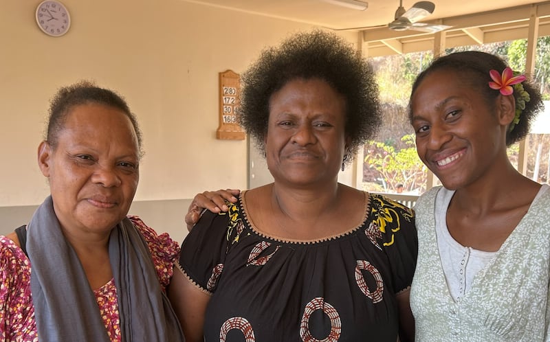 Da esquerda para a direita: Betty Aputa, primeira conselheira da Sociedade de Socorro do Ramo Eight Mile; Rebecca Aga, presidente da Sociedade de Socorro do Ramo Eight Mile; e Kitana Teukari, uma nova convertida, fotografadas em julho de 2026.
