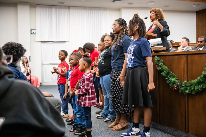 Crianças do Fort Worth Save our Children Learning Center cantam músicas que aprenderam no Learning Center que ajudam a memorizar escrituras, planetas, continentes e oceanos no o devocional Saints in Unity em Fort Worth, Texas, em 16 de novembro de 2025.