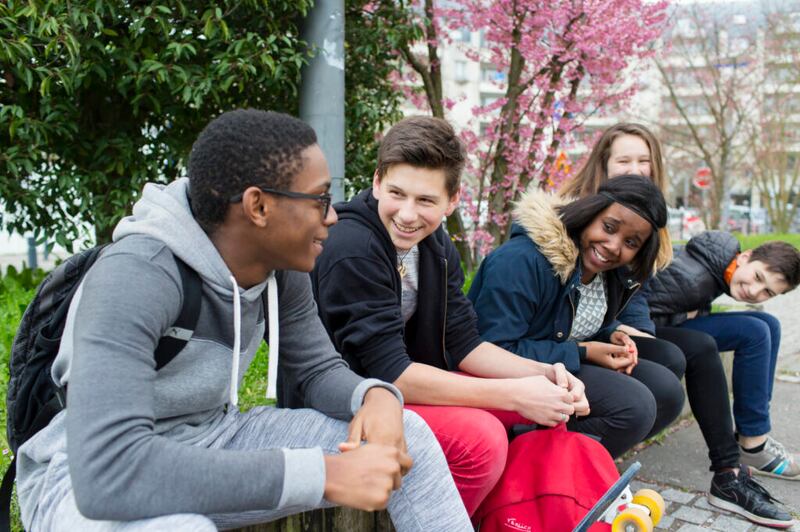 Um grupo de jovens santos dos últimos dias socializam juntos. (Nota: Esta imagem foi tirada antes da pandemia de COVID-19 e não reflete as atuais precauções de distanciamento social).