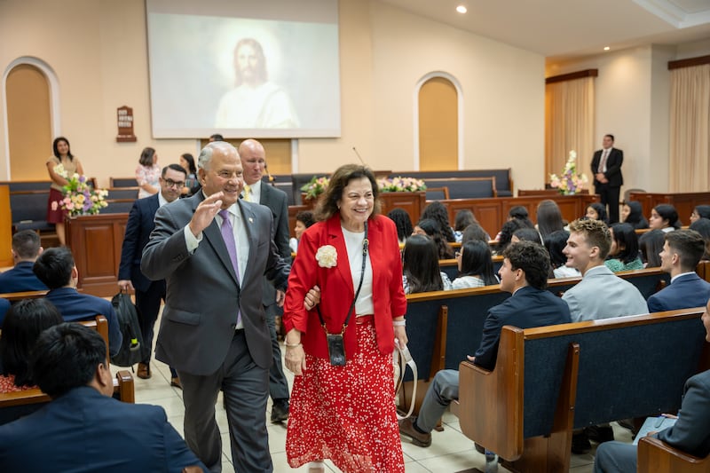 Élder Ronald A. Rasband do Quórum dos Doze Apóstolos e sua esposa, Irmã Melanie Rasband, acenam para os missionários após o devocional em Manágua, Nicarágua, na sexta-feira, 16 de outubro de 2026.