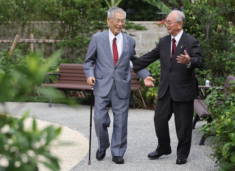 Kensei Nagamine e Akira Yafuso, líderes pioneiros em Okinawa, caminham pelo jardim do Templo de Okinawa Japão, em Okinawa, na sexta-feira, 10 de novembro de 2023.