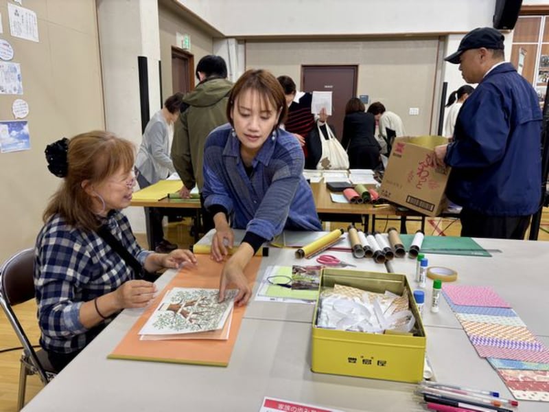 Participantes criam rolos de história da família em uma feira de história da família de Kyoto, Japão, 25 de outubro de 2025.