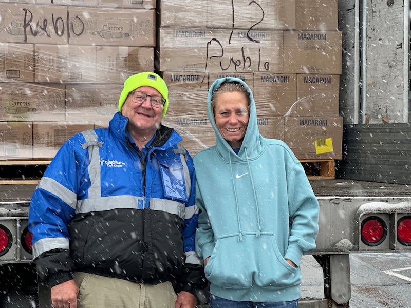 Gerente do armazém Ron Higby, à esquerda, e diretora executiva Stephanie Walker, à direita, de Cooperativa de Cuidados de Pueblo, posam para uma foto antes de descarregar um caminhão de alimentos da Igreja de Jesus Cristo dos Santos dos Últimos Dias em 3 de dezembro de 2025.