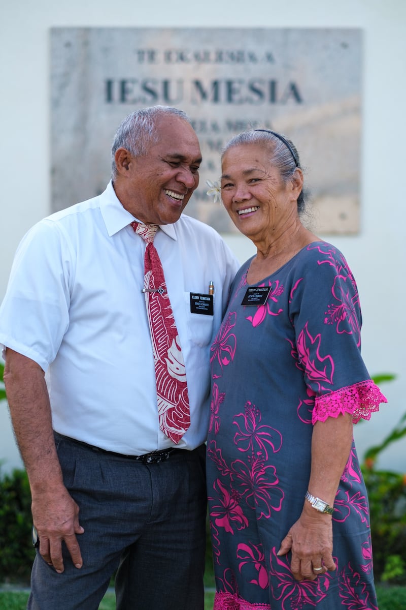 Um casal de missionários sênior está em pé perto de um templo da Igreja de Jesus Cristo dos Santos dos Últimos Dias no Taiti em 2026.